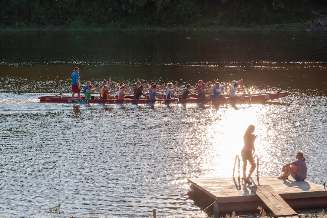 Group paddling together on calm water at golden hour