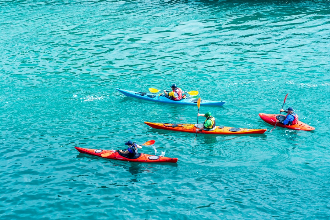 Colorful kayaks with paddlers on bright turquoise water